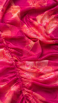 Tissu fuchsia de robe à imprimé floral abstrait multicolore, drapé texturé.