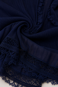 Tissu plissé bleu marine avec bordure dentelle crochetée et volant décoratif.