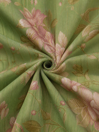 Tissu vert texturé à fleurs roses et feuilles, vue rapprochée.