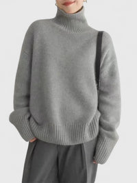 Pull à col montant gris, maille douce, col relevé et poignets côtelés.