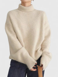Pull à col montant beige, maille texturée, col et poignets côtelés, manches longues.