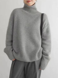 Pull gris à col montant, manches longues et poignets côtelés, coupe décontractée.