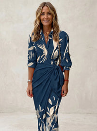 Robe longue à imprimé bleu marine et feuilles blanches, ceinture nouée.