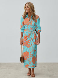 Robe midi turquoise à imprimé floral orange, ceinture à la taille, manches trois-quarts.