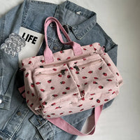 Sac cabas rose à motifs fraises, poches zippées avant et anses courtes