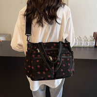 Sac cabas noir imprimé cerises rouges, bandoulière réglable et poches zippées