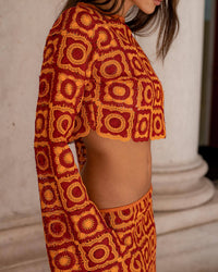 Haut court orange à motifs géométriques, manches longues évasées, détail du dos et taille