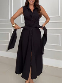 Robe midi noire sans manches, col chemise, boutons et ceinture, pans latéraux