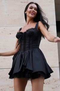 Robe courte sans manches noire, encolure carrée froncée et jupe bouffante