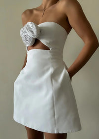 Robe courte blanche sans bretelles, ajustée avec fleur décorative sur le buste