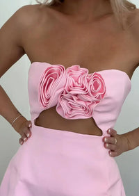 Robe courte rose pâle sans bretelles, fleur appliquée en relief sur le buste
