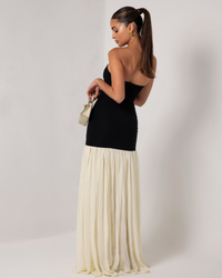Robe longue sans manches vue de dos : buste noir et jupe plissée ivoire
