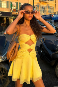 Robe courte jaune à décolleté noué, anneaux dorés et coupe évasée