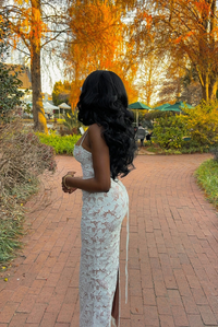 Robe longue en dentelle blanche avec dos nu et bretelles fines.