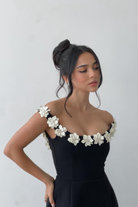 Robe courte noire sans manches, appliqués fleurs blanches sur l’épaule et l’encolure