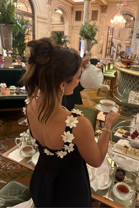 Robe courte noire vue de dos, appliqués fleurs blanches sur les épaules