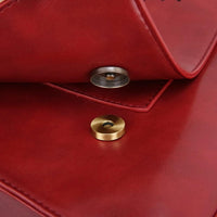 Fermoir à pression doré sur cuir rouge, couture et coin visibles