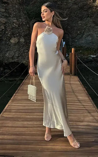Robe longue satin crème dos nu, encolure haute et fleur au buste