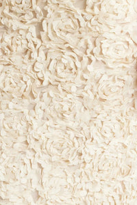 Détail de tissu beige avec fleurs en relief façon dentelle, surface en relief texturé