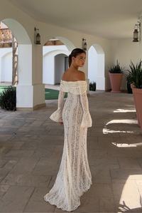 Robe longue en dentelle blanche, encolure épaules dénudées, manches longues évasées