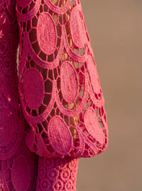 Détail robe en dentelle rose : motifs ovales en relief ajouré, tissu fin transparent
