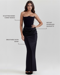 Robe longue noire bustier gainant, drapé froncé et silhouette près du corps.