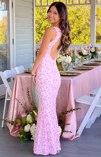 Robe longue rose sans manches à décolleté en V, motif floral, bords évasés en bas.