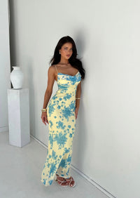 Robe longue ajustée jaune clair à motif floral bleu, bretelles fines et fente bas.
