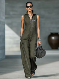 Combinaison minimaliste vert foncé, sans manches, zip devant, poche poitrine, coutures claires.