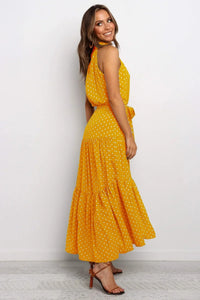 Robe longue à pois jaune, col montant haut, sans manches, taille ceinturée.
