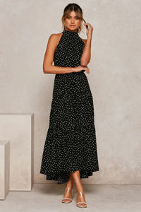 Robe longue à pois noirs, col montant sans manches, ceinture à nouer.