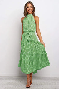 Robe longue à pois vert clair, col montant haut, ceinture nouée, sans manches.