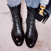 Bottes montantes en cuir noir à lacets, profil avant avec bout brillant.