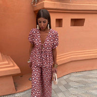 Ensemble pantalon rose à imprimé blanc : haut décolleté en V, manches bouffantes et pantalon long