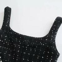 Encolure carrée d’une robe noire à bretelles fines, perles blanches