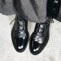 Bottes en cuir noir, fermeture à lacets, bout pointu et semelle épaisse.