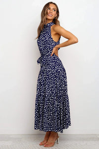 Robe longue Zaria bleu nuit à pois blancs, encolure haute, sans manches, jupe longue.