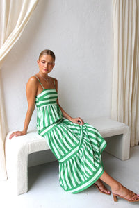 Robe longue à bretelles rayée vert et blanc, jupe évasée à volants superposés.