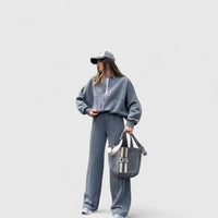 Ensemble pull en maille et pantalon gris, coupe ample, cordon à la taille.
