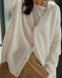 Gilet cocon ivoire en maille côtelée, col V et boutons bois, coupe ample, manches longues.