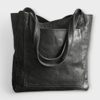 Sac à main noir, effet cuir, ouverture supérieure et anses longues.
