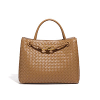 Sac cabas tressé beige clair, anse rigide et fermoir décoratif doré.