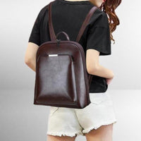 Sac à dos classique marron foncé en cuir, poche avant zippée et bretelles réglables