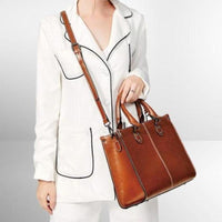 Sac cabas en cuir brun avec bandoulière, porté sur l’épaule