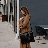 Sac à main cartable noir, rabat avec perforations discrètes et nœud