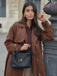 Sac tressé marron foncé avec anse rigide et fermoir décoratif doré.