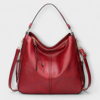 Grand sac hobo rouge en cuir, anses et bandoulière réglables, poche zippée frontale.