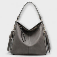 Grand sac hobo gris en cuir, anses hautes et bandoulière réglable, zip central.