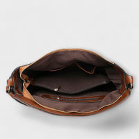 Intérieur du grand sac hobo marron : doublure sombre et poches zippées.