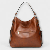 Grand sac hobo marron avec poche zippée frontale, anses et bandoulière amovibles.